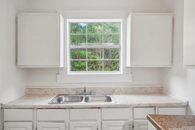 kitchen featuring white cabinetry, a healthy amount of sunlight, light countertops, and a sink