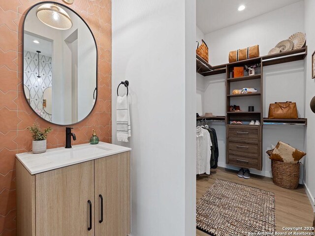 630 Central Pkwy Unit 1113, New Braunfels, TX 78130 - bathroom featuring recessed lighting, wood finished floors, vanity, baseboards, and a spacious closet