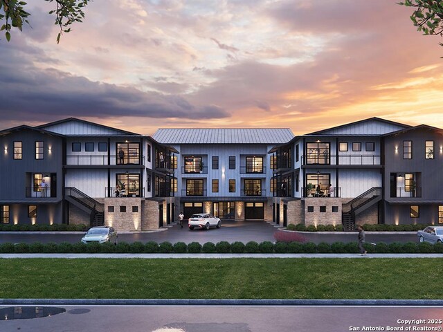 630 Central Pkwy Unit 1113, New Braunfels, TX 78130 - rear view of house with metal roof, stairs, a yard, and a balcony