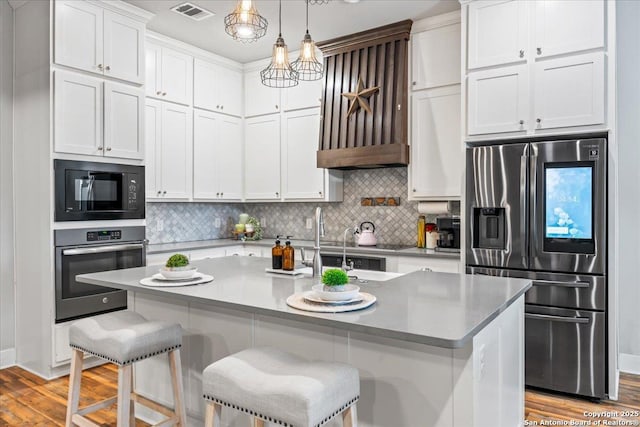 1547 Moon Vw, New Braunfels, TX 78132 - kitchen with appliances with stainless steel finishes, light wood-type flooring, white cabinetry, and backsplash