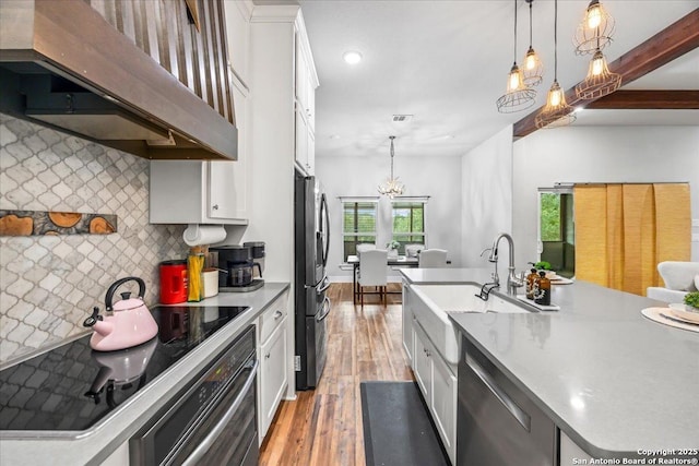 1547 Moon Vw, New Braunfels, TX 78132 - kitchen featuring under cabinet range hood, stainless steel appliances, white cabinetry, decorative backsplash, and recessed lighting