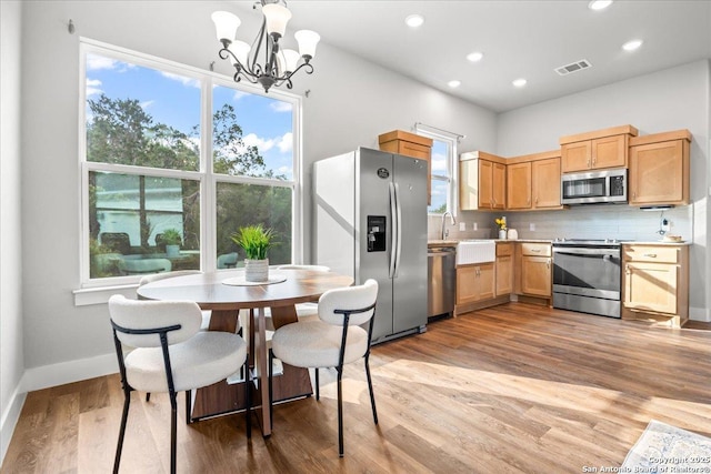 1547 Moon Vw, New Braunfels, TX 78132 - kitchen with appliances with stainless steel finishes, light countertops, decorative backsplash, a chandelier, and recessed lighting