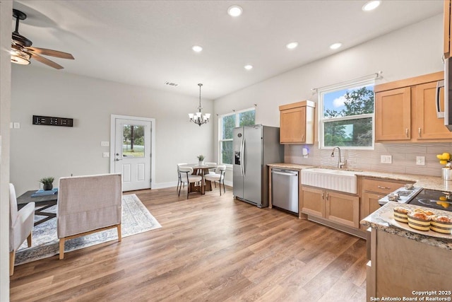 1547 Moon Vw, New Braunfels, TX 78132 - kitchen featuring appliances with stainless steel finishes, decorative backsplash, a chandelier, recessed lighting, and light wood-style flooring