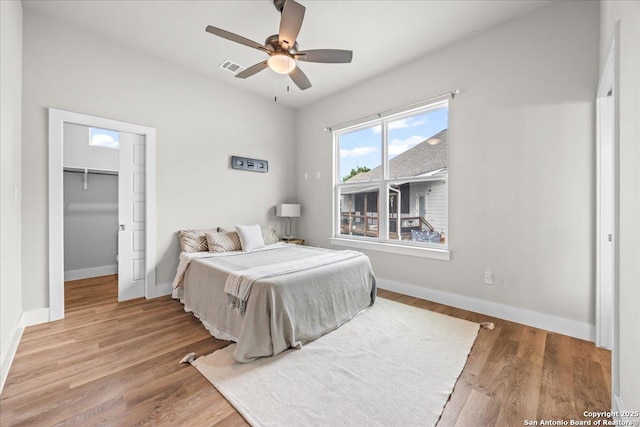 1547 Moon Vw, New Braunfels, TX 78132 - bedroom featuring wood finished floors, baseboards, a walk in closet, ceiling fan, and a closet