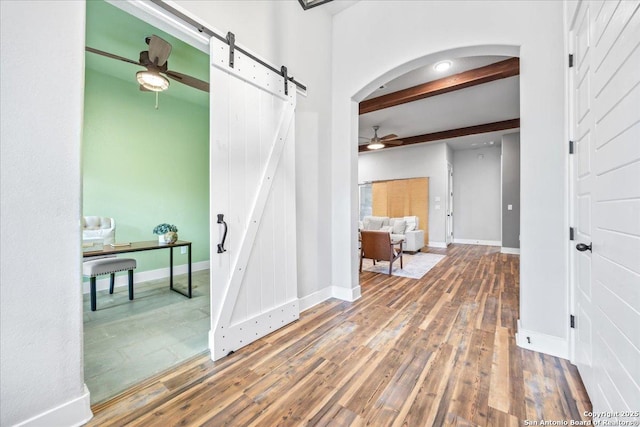 1547 Moon Vw, New Braunfels, TX 78132 - corridor with a barn door, wood finished floors, beam ceiling, arched walkways, and baseboards