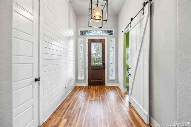 1547 Moon Vw, New Braunfels, TX 78132 - foyer featuring a barn door, wood-type flooring, and baseboards