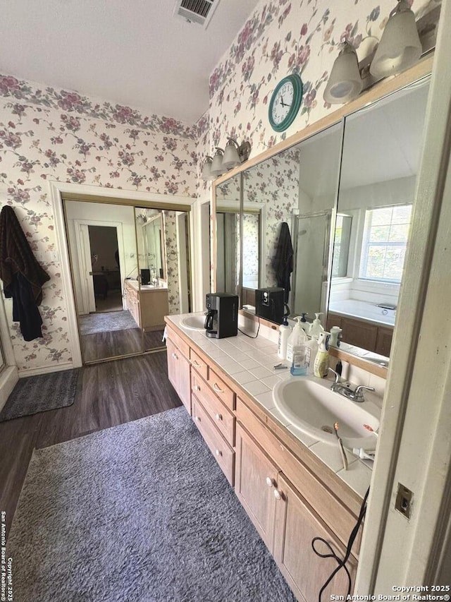 607 Dover Ln, Round Rock, TX 78664 - full bath featuring a sink, visible vents, a stall shower, wallpapered walls, and wood finished floors