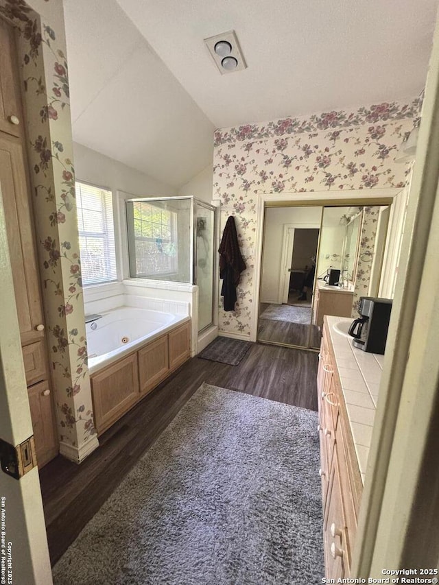 607 Dover Ln, Round Rock, TX 78664 - bathroom featuring wallpapered walls, wood finished floors, a shower stall, and vaulted ceiling