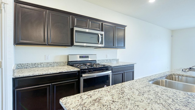 13406 Flower Pond, Saint Hedwig, TX 78152 - kitchen with dark brown cabinetry, stainless steel appliances, light stone countertops, and a sink