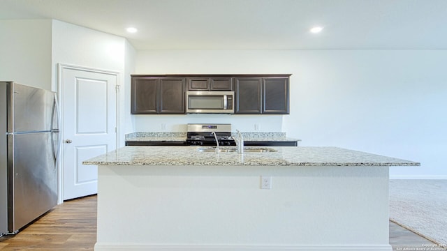 13406 Flower Pond, Saint Hedwig, TX 78152 - kitchen with a sink, stainless steel appliances, dark brown cabinetry, light stone countertops, and an island with sink