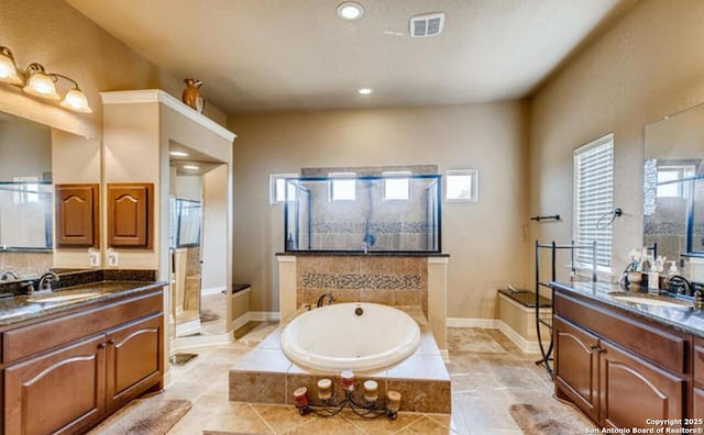full bathroom with a garden tub, recessed lighting, two vanities, and a sink