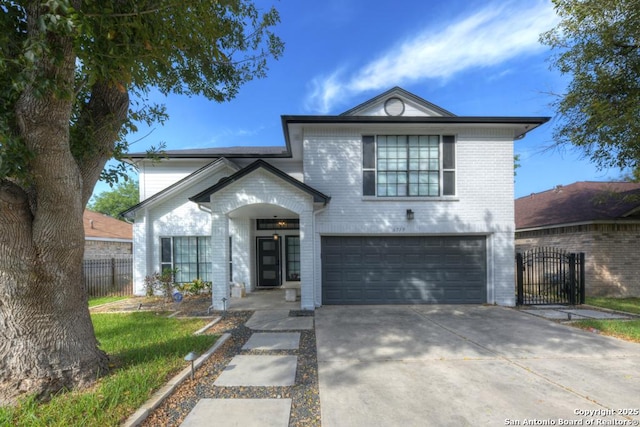 view of front of property with a gate, brick siding, concrete driveway, an attached garage, and fence