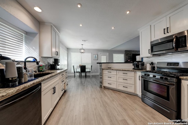 kitchen featuring backsplash, a sink, appliances with stainless steel finishes, and white cabinetry
