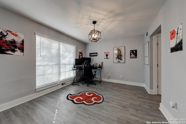office area featuring a chandelier, wood finished floors, and baseboards