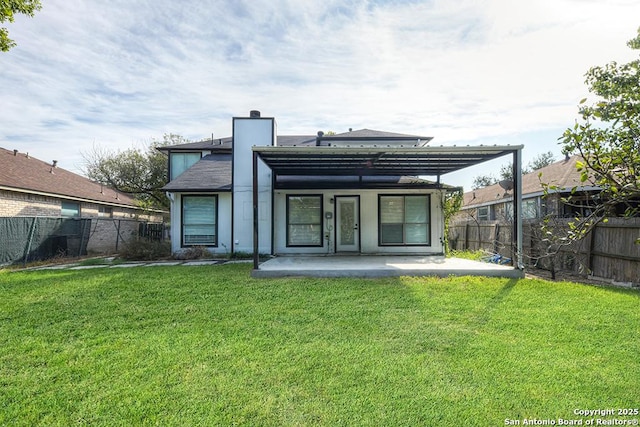 back of property featuring a yard, a fenced backyard, and a chimney