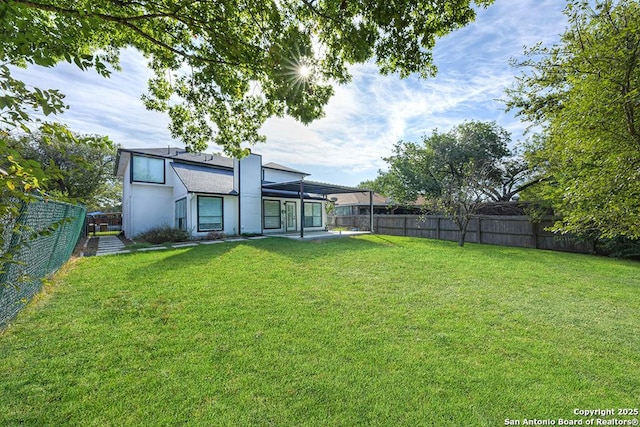 back of property featuring a yard, stucco siding, and a fenced backyard
