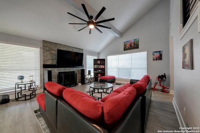living room featuring baseboards, a fireplace, wood finished floors, a ceiling fan, and high vaulted ceiling