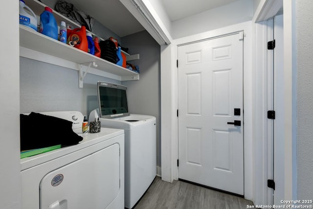laundry area with independent washer and dryer, laundry area, and light wood-style floors