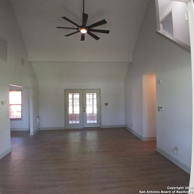 unfurnished living room featuring high vaulted ceiling, wood finished floors, ceiling fan, and french doors