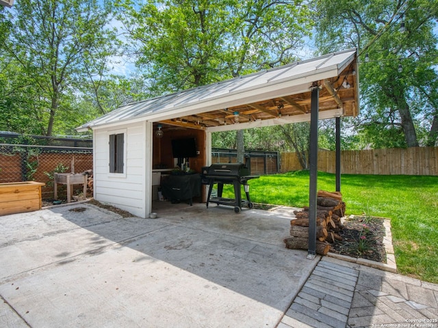 view of patio / terrace featuring a carport, a fenced backyard, grilling area, and an outbuilding