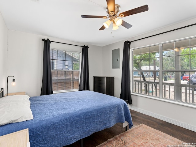 bedroom featuring baseboards, wood finished floors, ceiling fan, and electric panel