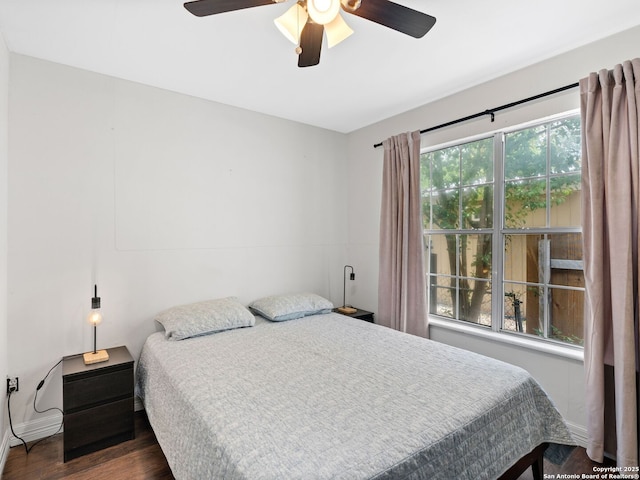 bedroom with dark wood-style floors, baseboards, and ceiling fan