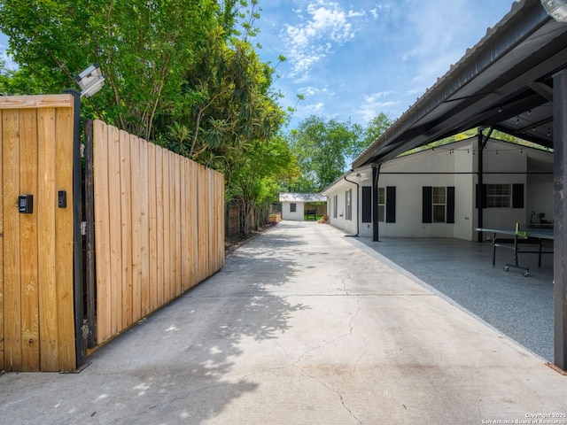 exterior space featuring a gate, fence, and stucco siding