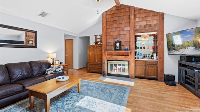 8422 Timber Crst, San Antonio, TX 78250 - living room with visible vents, light wood-type flooring, a fireplace, and vaulted ceiling