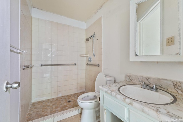 bathroom featuring vanity, toilet, and tiled shower