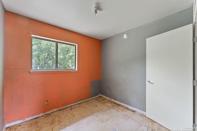 empty room featuring baseboards and tile patterned floors