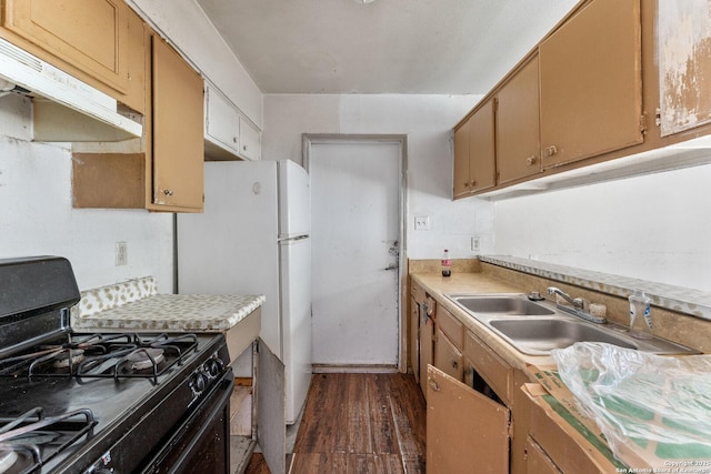 kitchen with a sink, light countertops, under cabinet range hood, black range with gas stovetop, and dark wood finished floors