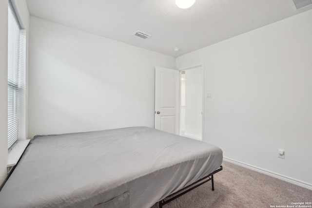 carpeted bedroom featuring visible vents and baseboards