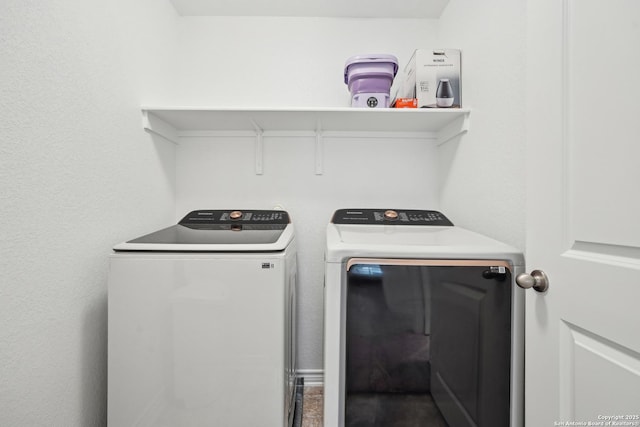clothes washing area featuring separate washer and dryer and laundry area