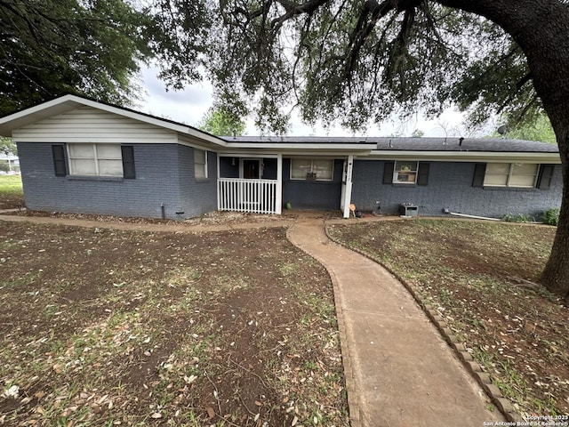 ranch-style house featuring covered porch and brick siding