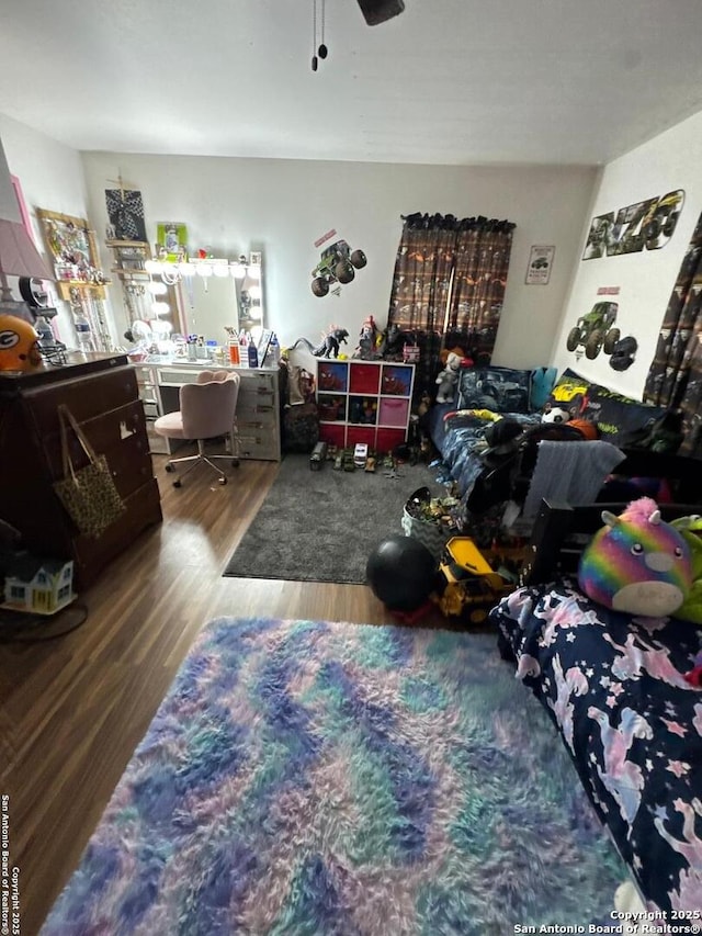 bedroom featuring wood finished floors, a desk, and a ceiling fan