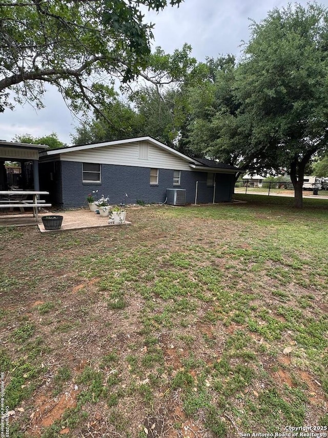 view of side of home with central air condition unit and brick siding