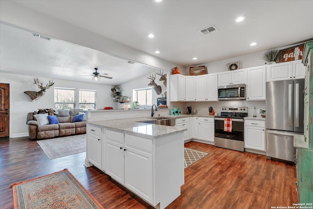 kitchen featuring a sink, visible vents, stainless steel appliances, a peninsula, and a ceiling fan
