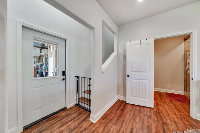 foyer entrance featuring baseboards and wood finished floors