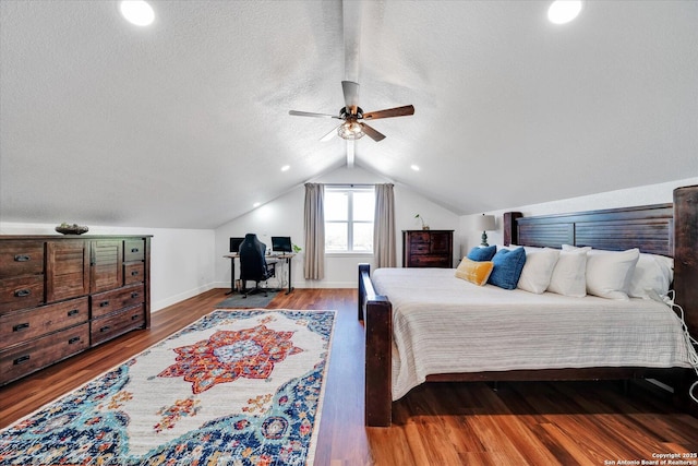 bedroom with wood finished floors, baseboards, a ceiling fan, a textured ceiling, and lofted ceiling