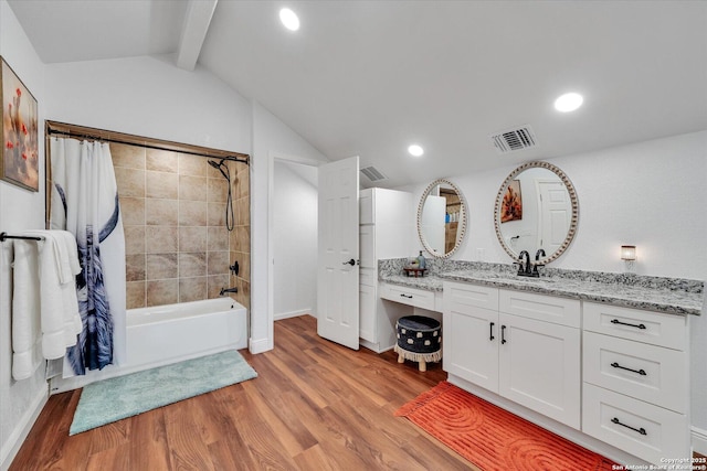 bathroom with shower / tub combo, visible vents, vaulted ceiling with beams, and wood finished floors