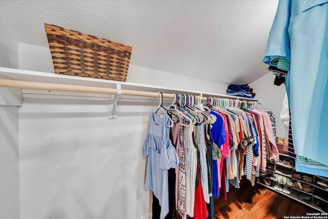walk in closet featuring lofted ceiling and wood finished floors