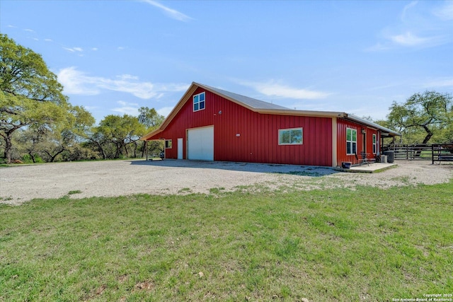 view of outbuilding with an outbuilding, gravel driveway, and fence