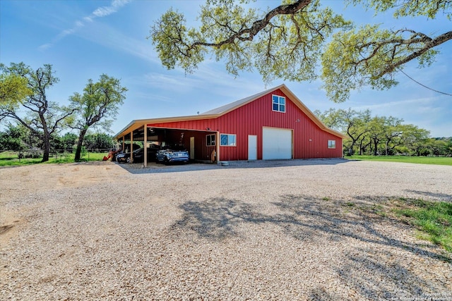 view of pole building with gravel driveway