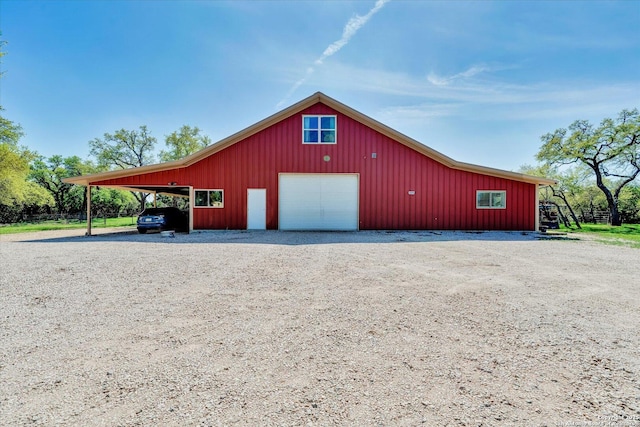 view of pole building with gravel driveway