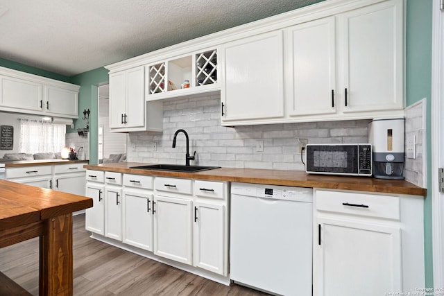 kitchen with a sink, open shelves, backsplash, wooden counters, and dishwasher