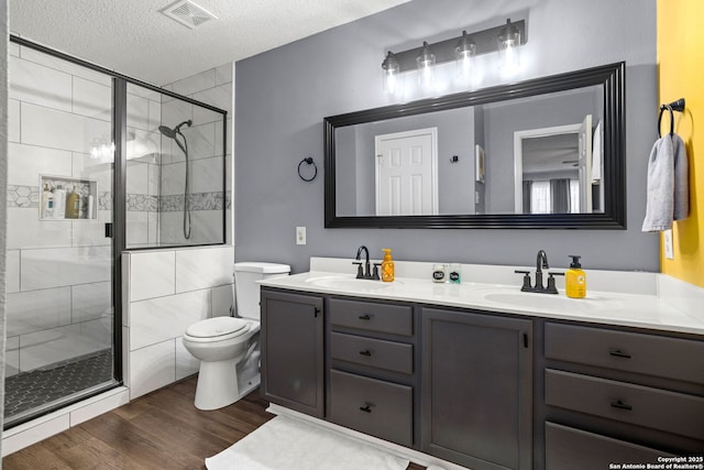 bathroom with visible vents, wood finished floors, toilet, and a sink