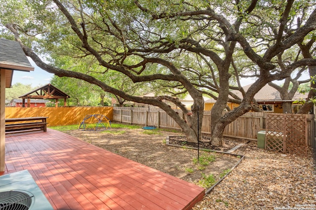 wooden terrace with a fenced backyard