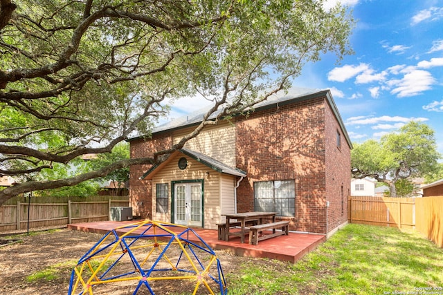 back of property featuring a wooden deck, central AC unit, french doors, brick siding, and a fenced backyard