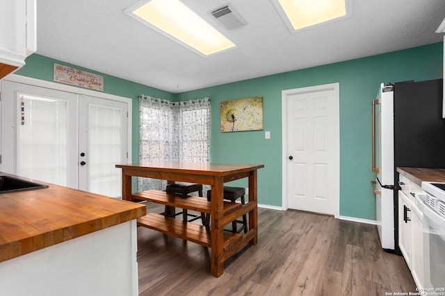 interior space with french doors, visible vents, dark wood-style flooring, and baseboards