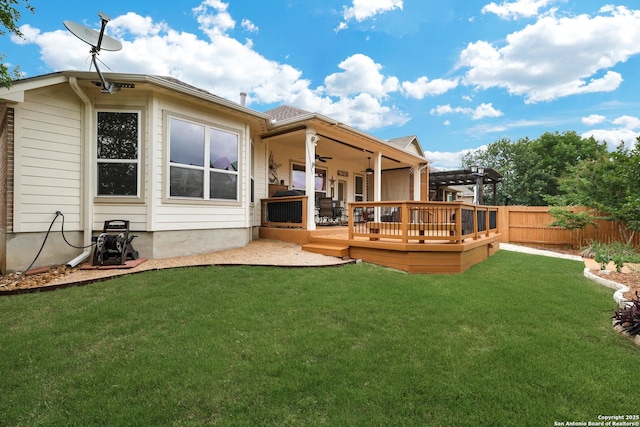back of house featuring a wooden deck, a pergola, fence, a ceiling fan, and a lawn
